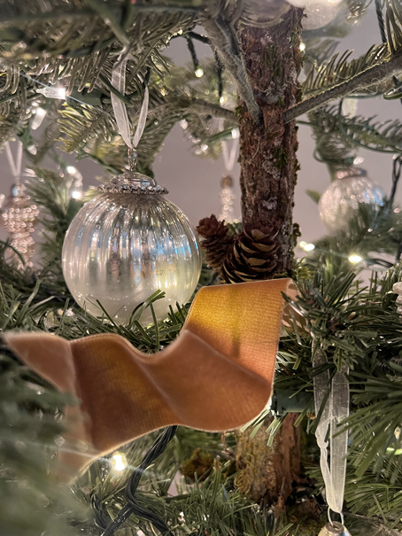 Christmas ornament in twinkling lights on a realistic artificial Christmas tree