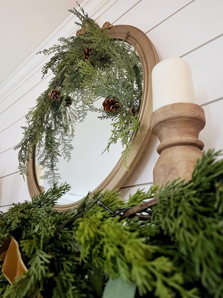 Vintage gold mirror makeover using Rub'-N-Buff: A small pine swag and pinecones attached over a Christmas mantel