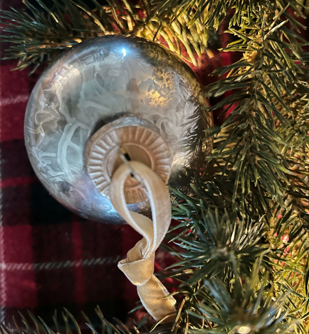 Christmas ornament in twinkling lights. Plastic ornaments that looks like vintage mercury glass in silver and gold. 