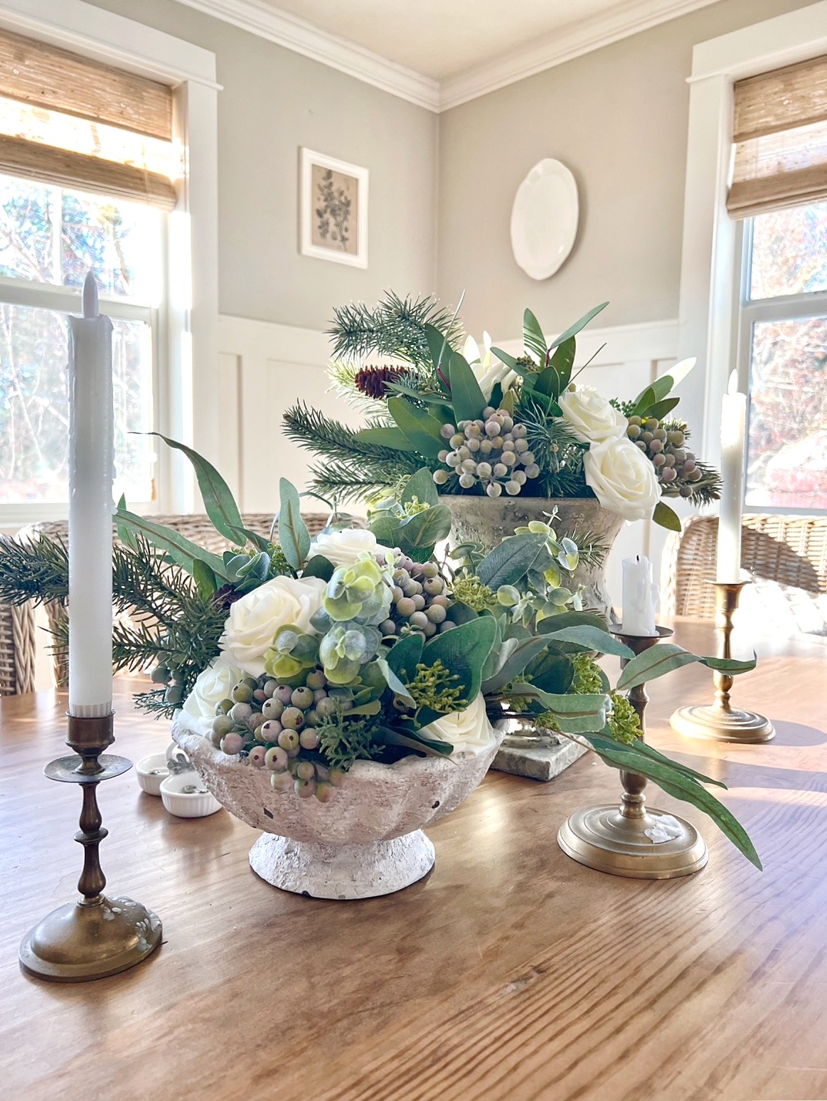 Close up view of winter flower bouquet made of green eucalyptus, green pine, white roses, and green-blue frosted berries.