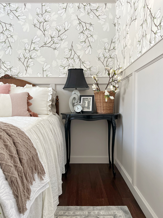 DIY board and batten wainscoting painted light gray in bedroom with magnolia floral wallpaper on the top portion of the wall. 