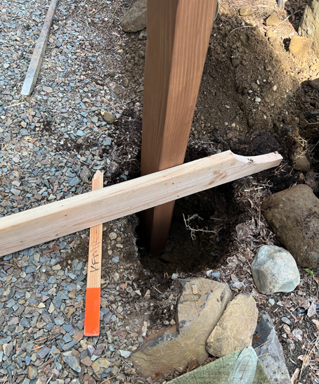 Easy DIY garden arbor post in concrete hole with wood brace holding it level. 