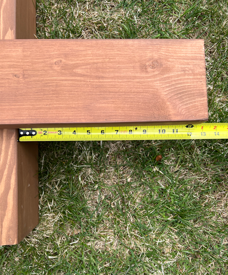 Measuring tape measures 13 inches from beam end to post for the beam overhang. 