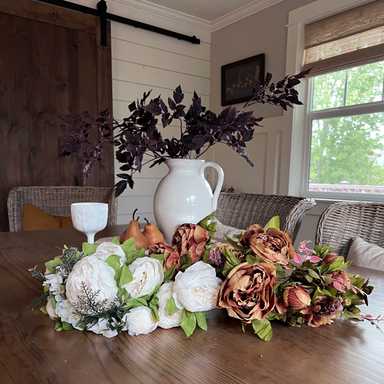 Floral bouquets in soft coffee orange, cream and white on a wood table.