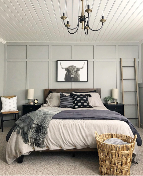 DIY Design and The Golden Ratio in a boys bedroom with gray board and batten walls, a black and white bull painting, bed with neutral bedding and and wood and black chandelier. 
