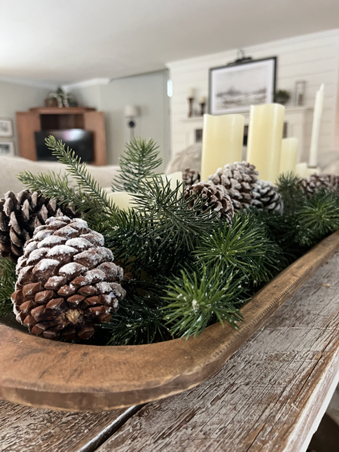 Easy DIY Winter Frosted Pinecones in a doughbowl with pine garland and candles.