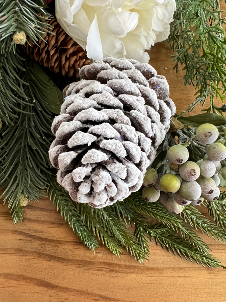 Easy DIY Winter Frosted Pinecones with pine, winter berries and white peonies.