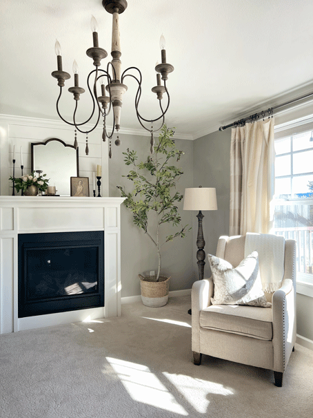 Wood base farmhouse style floor lamp in a European farmhouse room with ivory sitting chairs and white fireplaces on either side